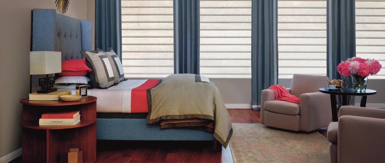 Bedroom with blue fabric headboard and matching floor to ceiling curtains